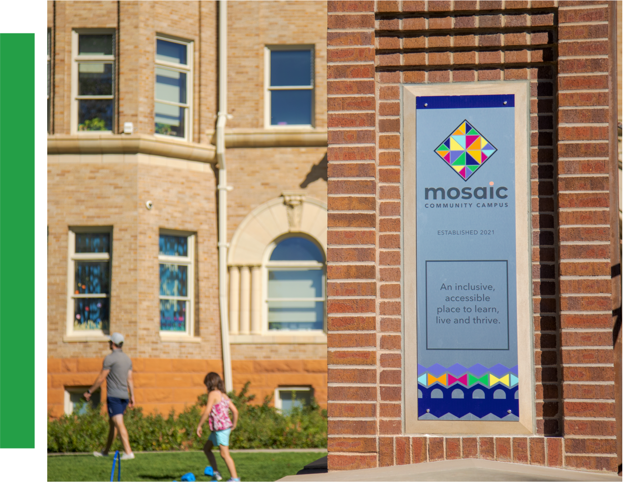 A sign that reads " Mosaic Community Campus: An inclusive, accessible place to learn, live, and thrive". Children are playing in the background.